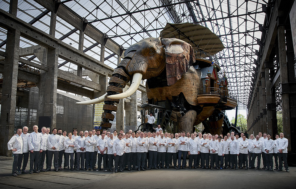 Groupe de chefs en uniformes blancs posant pour une photo