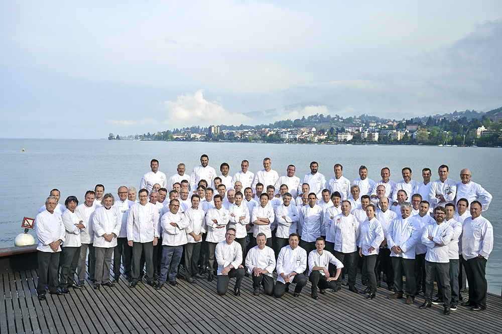 Groupe de chefs en uniformes blancs posant pour une photo