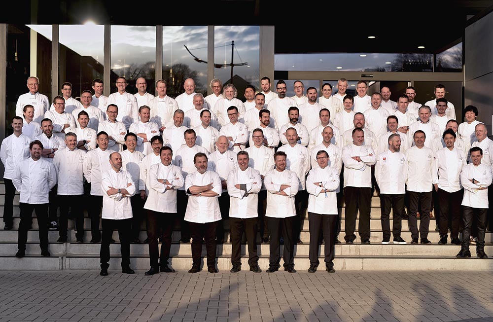 Groupe de chefs en uniformes blancs posant pour une photo