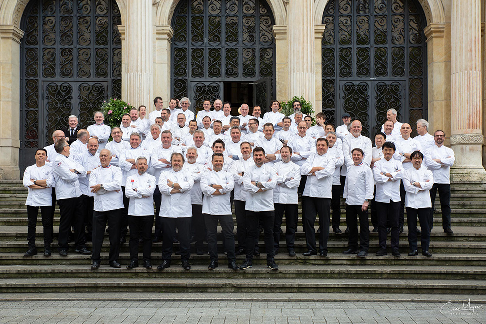 Groupe de chefs en uniformes blancs posant pour une photo