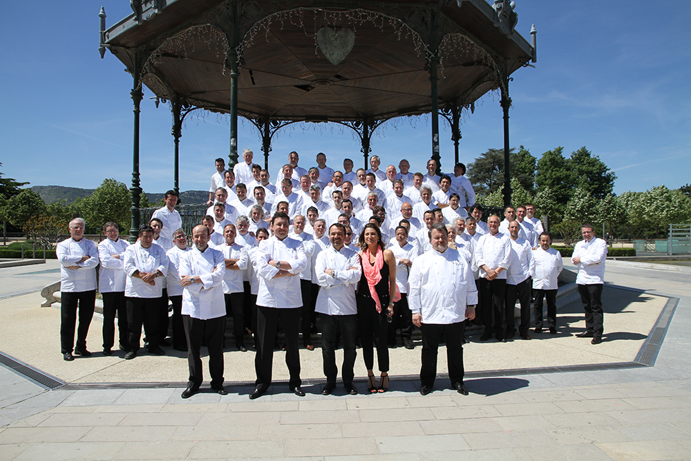 Groupe de chefs en uniformes blancs posant pour une photo