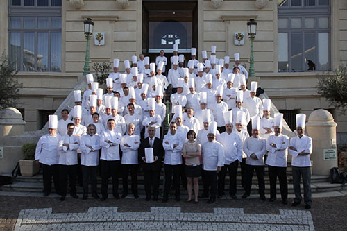 Groupe de chefs en uniformes blancs posant pour une photo